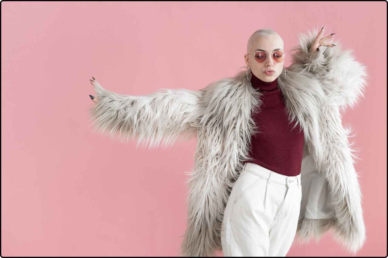 Woman in a luxurious fur coat performing a dance move in a minimalist studio.